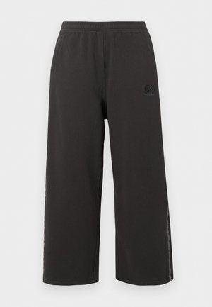 Schwarze, weit geschnittene Freizeithose mit elastischem Bund, Seitentaschen und dezentem Logo am linken Oberschenkel.