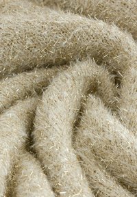 Tecido moale de culoare crem, cu fire metalice dense de aur țesute în întregime, arătând pliuri și fibre texturate de aproape.