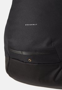 Zaino in tessuto nero con un logo del marchio discreto, superficie testurizzata e una tasca frontale con una cinghia orizzontale e dettagli in metallo.