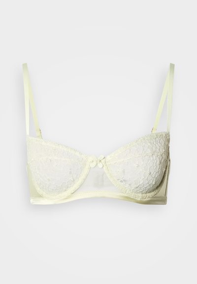 Sujetador de encaje amarillo claro con copas moldeadas, tirantes ajustables y detalle de lazo en el centro. Presenta paneles de encaje transparente y una banda de satén.