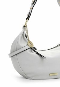 Borsa hobo in pelle bianca con una forma curva, caratterizzata da una tracolla nera a contrasto con dettagli in oro e una chiusura a zip. Dettaglio di nappina notevole.