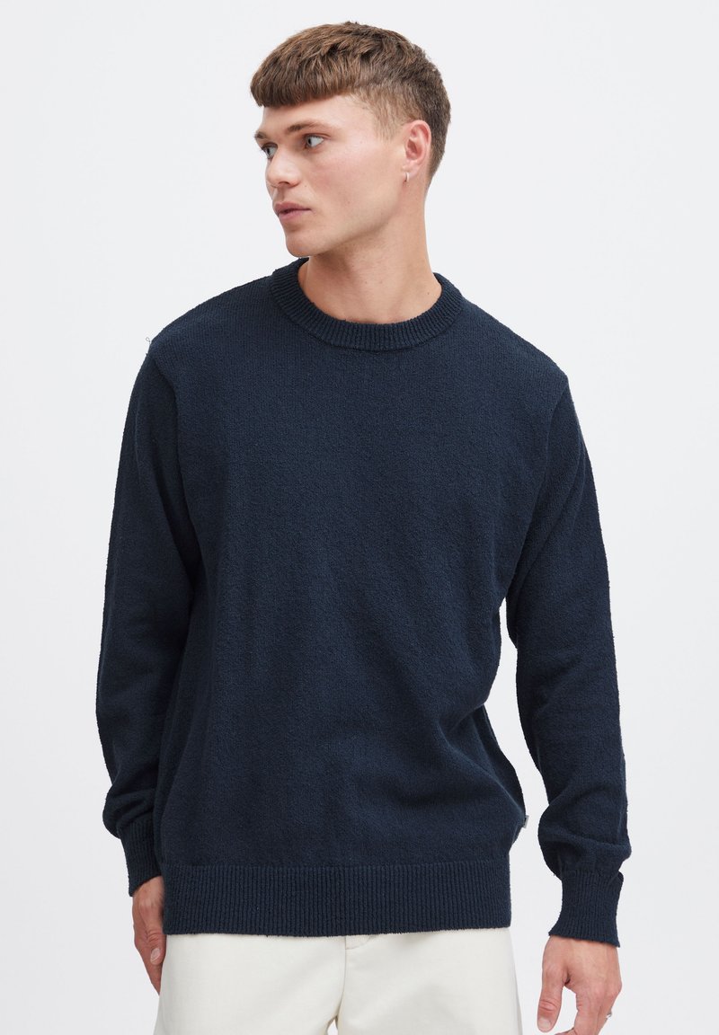 Maglione lavorato a maglia blu navy, collo rotondo, polsini e orlo a costine, finitura testurizzata, realizzato in tessuto morbido, vestibilità casual, dettaglio della etichetta laterale.
