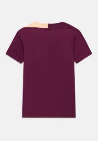 Bordó rövid ujjú póló barack színű vállrész díszítéssel, texturált anyagból, szabványos kerek nyakkivágással.