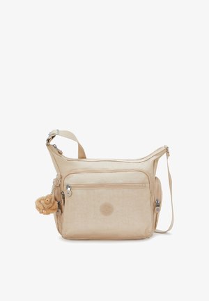 Beige crossbody bag with multiple zippered pockets, adjustable strap, and a small plush monkey keychain attached to the side.