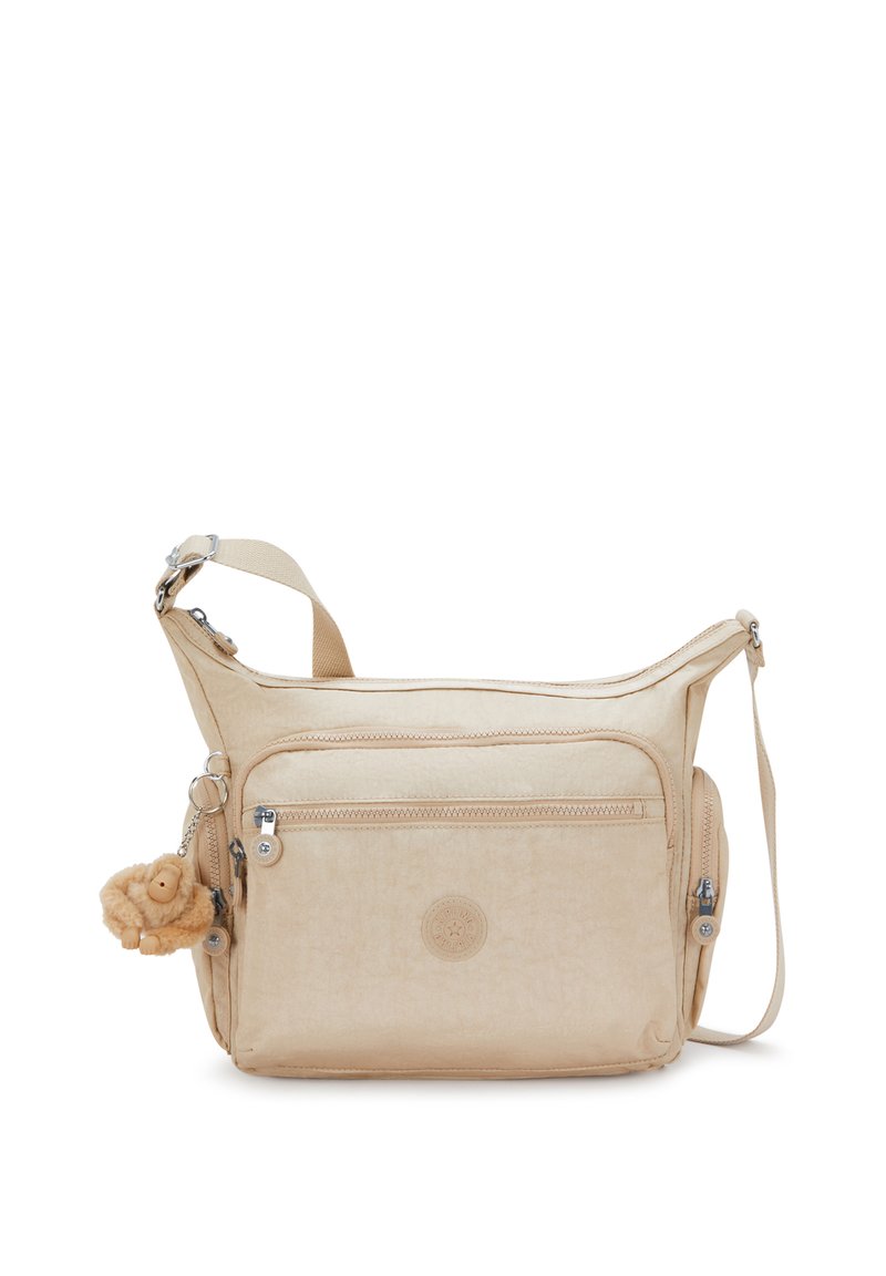 Borsa a tracolla beige con numerose tasche con zip, tracolla regolabile e un piccolo portachiavi a forma di scimmietta in peluche attaccato di lato.