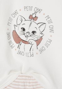 White fabric featuring an illustrated cat with a bow, surrounded by the text "PETIT CHAT" in a circular layout. Soft, lightweight material.