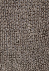 Nahaufnahme eines locker gestrickten Stoffes mit dicker, glänzender taupefarbener Wolle, die ein Netzmuster mit sichtbaren Lücken zwischen den Maschen bildet.