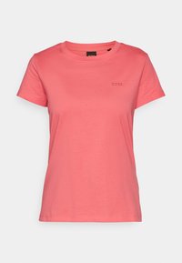 T-shirt corail rose à manches courtes et col rond avec un petit logo "BOSS" brodé sur la poitrine gauche.