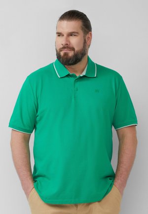 Groene poloshirt met een gestructureerde afwerking. Heeft een kraag met een witte bies en drie knopen bij de hals. Korte mouwen, geen patronen.