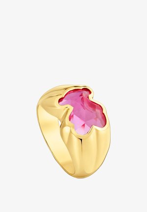 Anillo de oro con una gran piedra preciosa rosa facetada de forma irregular, con un acabado liso y pulido y un diseño audaz.