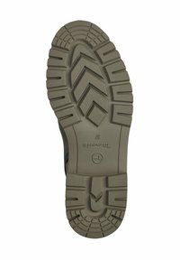 Semelle de chaussure en caoutchouc brun avec des rainures profondes, présentant un motif en zigzag et le nom de la marque "TOMS" en relief. Surface durable et texturée pour plus d'adhérence.