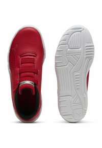 Punased spordijalatsid, millel on sile sünteetiline pealis, elastne nööbikinnitusega ja valge kummist põhi, millel on tekstuuriga haardemuster.