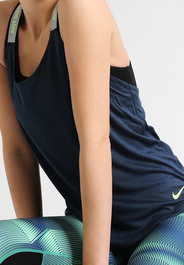 Marinblå atletisk linne utan ärmar, med rund halsringning och texturerad tyg. Inkluderar "Just Do It"-detaljer på axelremmarna.