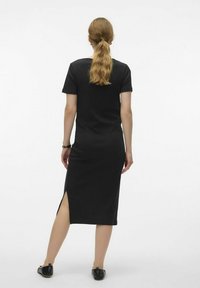 Robe midi noire côtelée à manches courtes, avec une fente sur le côté et une coupe ajustée. Simple, couleur unie sans motifs ni embellissements.