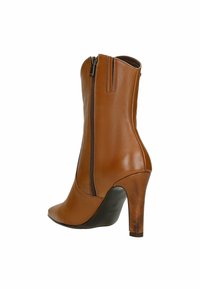 Hnědá kožená kotníková bota s špičatou špičkou, bočním zipem a stiletto podpatkem. Hladká textura a elegantní design s minimem akcentů.