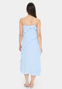 Rochie bleu deschis cu bretele ajustabile, având detalii volanate pe partea din față și un tiv fluid, până la genunchi.