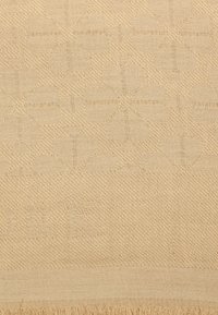 Beige tekstil med et subtilt geometrisk mønster, tekstureret overflade og frynset kanter. Fremstillet af blødt, vævet materiale.