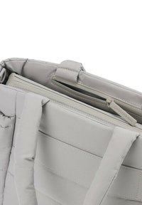 Borsa per laptop grigia imbottita con due manici morbidi, una tasca con zip e una superficie liscia. Presenta cuciture a contrasto e un'etichetta del marchio.