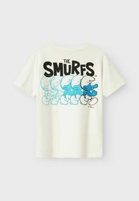 Camiseta de algodón blanca con un gráfico en negro y azul que presenta múltiples Pitufo en diversas poses, con el texto "LOS PITUFOS" arriba.