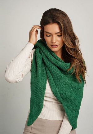 Green knit scarf with a textured pattern, draping loosely around the shoulders. Soft material and triangular shape, providing warmth.