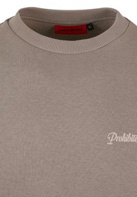 Világosszürke pulóver bordázott kerek nyakkal, elöl piros "TILTVA" felirattal és fehér írásos szöveggel.