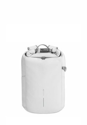 Sac à dos blanc avec des bretelles rembourrées, surface texturée, poche avant et fermoir sécurisé. Design simple et moderne avec un branding discret.
