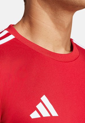 Rode sportieve T-shirt met een ronde hals, een gladde textuur en een wit Adidas-logo met drie witte strepen op de schouders.