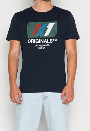 T-shirt en coton bleu marine avec un logo graphique en rouge, blanc et vert. Manches courtes et col rond avec une coupe décontractée.