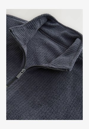 Dark gray fleece pullover with a high collar and half-zip closure. Textured fabric with ribbed lines and a flat zipper pull accent.