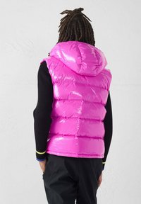 Gilet imbottito aderente in rosa brillante lucido, con cappuccio e design trapuntato. Il retro presenta una texture liscia con cuciture visibili.