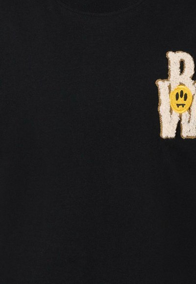 Zwart katoenen T-shirt met een textuur witte logo en een gele glimlachende gezichtaccent aan de voorkant. Ronde halslijn, standaard pasvorm.