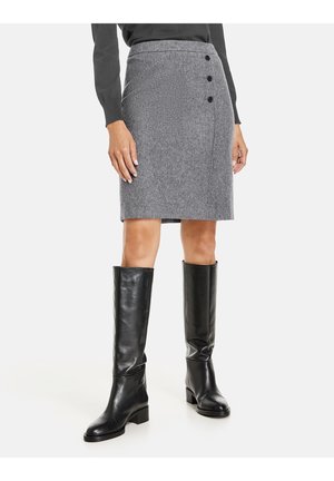 Jupe crayon en mélange de laine grise avec une coupe ajustée, ornée de boutons noirs sur le côté, associée à des bottes en cuir noir jusqu'aux genoux.
