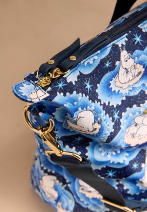 Modrý batoh s potiskem Moomin postaviček, vyrobený z odolné látky. Zlaté kovové detaily a tmavě modrý zip zvýrazňují design.