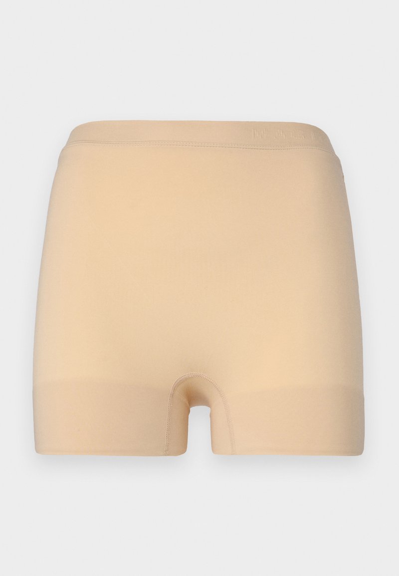Shorts beige sin costuras, hechos de una tela suave y elástica, con una cintura de altura media y una abertura de pierna redondeada, que presentan bordes suaves y costuras mínimas.