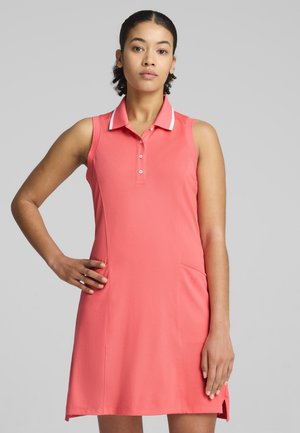 Korallfärgad poloklänning med krage, korta ärmar och en sidficka. Har en enfärgad design och en vit accent på kragen.