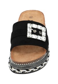 Sandale en daim noir à glissière avec une boucle décorative en strass carrée, plateforme tressée composée d'un mélange de fils noirs, blancs et argentés.