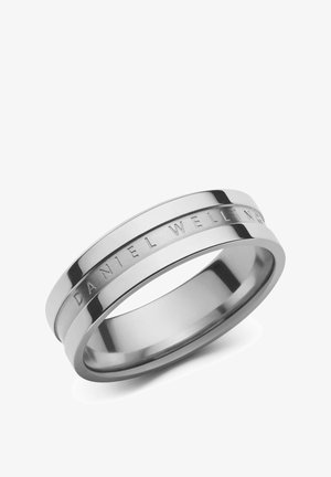 Anillo de acero inoxidable pulido con una forma suave y redondeada. Presenta un acabado cepillado y grabados de "DANIEL WELLINGTON."