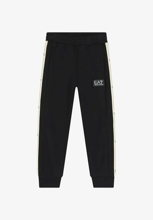Pantaloni jogger neri realizzati in tessuto morbido, con strisce laterali cream a contrasto e una patch con il logo EA7 sulla coscia. Vita elasticizzata.