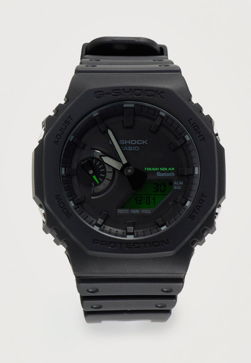 Μαύρο ρολόι Casio G-Shock με αναλογική και ψηφιακή οθόνη, που δείχνει ώρα 12:01, ηλιακή ενέργεια και λειτουργίες Bluetooth, στιβαρός σχεδιασμός με κουμπιά.