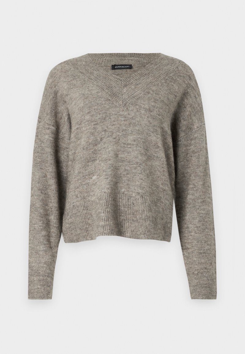 Pull à col en V, à manches longues, en tissu tricoté gris clair avec un ourlet côtelé. Texture légère, légèrement cropped avec une coupe décontractée.