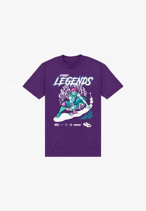 Fialové bavlněné tričko s grafickým potiskem postavy s růžovými vlasy a modrou pletí, zobrazující akční pozici s stylizovaným textem.