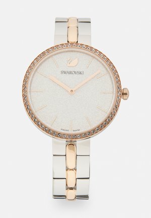 Swarovski-Uhr mit einem runden Silbergehäuse und einer rosegoldenen Lünette, funkelnden Kristallakzenten und einem strukturierten weißen Zifferblatt. Metall-Armband.