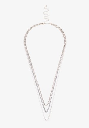 Collana a strati in argento con diversi design di catene: anelli sottili e spessi con outline a forma di V e chiusura regolabile.