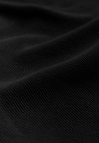 Must mustra, millel on sile tekstuur, millel on peen sooneline muster ja pehme langus, tuues esile tumeda värvi sügavuse.