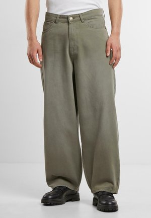 Wide-leg, olive green cotton pants with a smooth texture, featuring front pockets and a button closure, paired with black footwear.