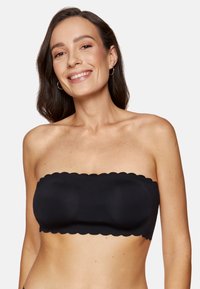Czarna bandeau bez ramiączek z falbaniastymi krawędziami, gładką teksturą i wspierającym designem. Idealna do noszenia w warstwach lub samodzielnie.