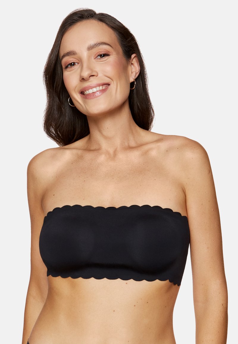 Czarna bandeau bez ramiączek z falbaniastymi krawędziami, gładką teksturą i wspierającym designem. Idealna do noszenia w warstwach lub samodzielnie.