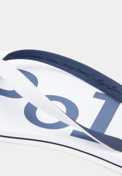 Biele žabky s tmavomodrými remienkami, na podrážke veľké modré čísla a na remienku vyrazený citát.