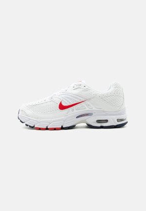 Baskets blanches de sport avec un swoosh Nike rouge, des panneaux en mesh, une semelle amortie avec unités d'air visibles, et des accents noirs et rouges sur la semelle extérieure.