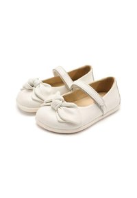 Scarpe Mary Jane bianche in pelle con dettaglio a nodo anteriore, cinturino regolabile e una superficie liscia. Suola piatta con leggera imbottitura.